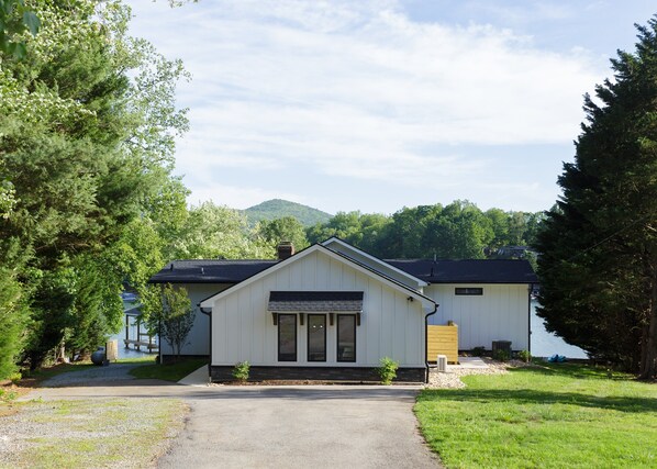 A white building with a front porch, a chimney, and a small window. - Lake Haven - 5 Bedroom w/ Hot tub and Private Dock (Penhook)