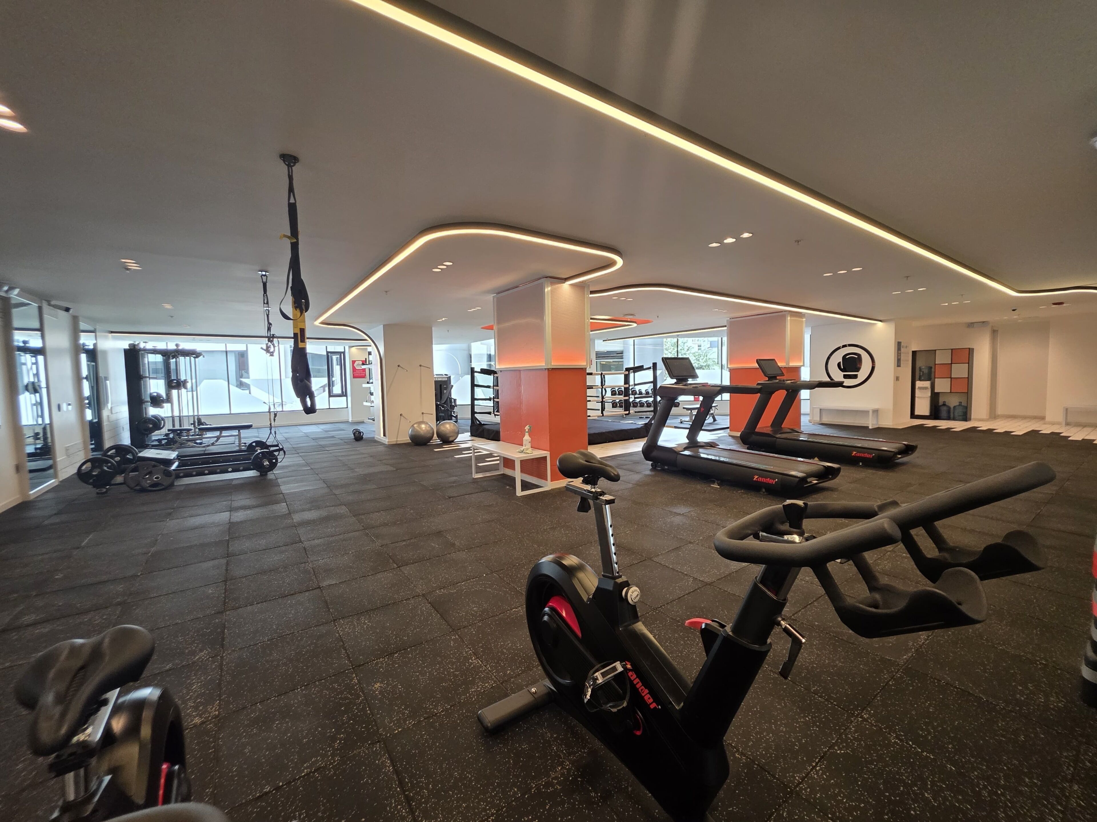 Ein Fitnessstudio mit Trainingsgeräten, Laufband und Ergometer.