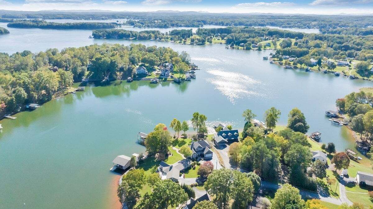 A lakeside property with multiple houses, docks, and boats.