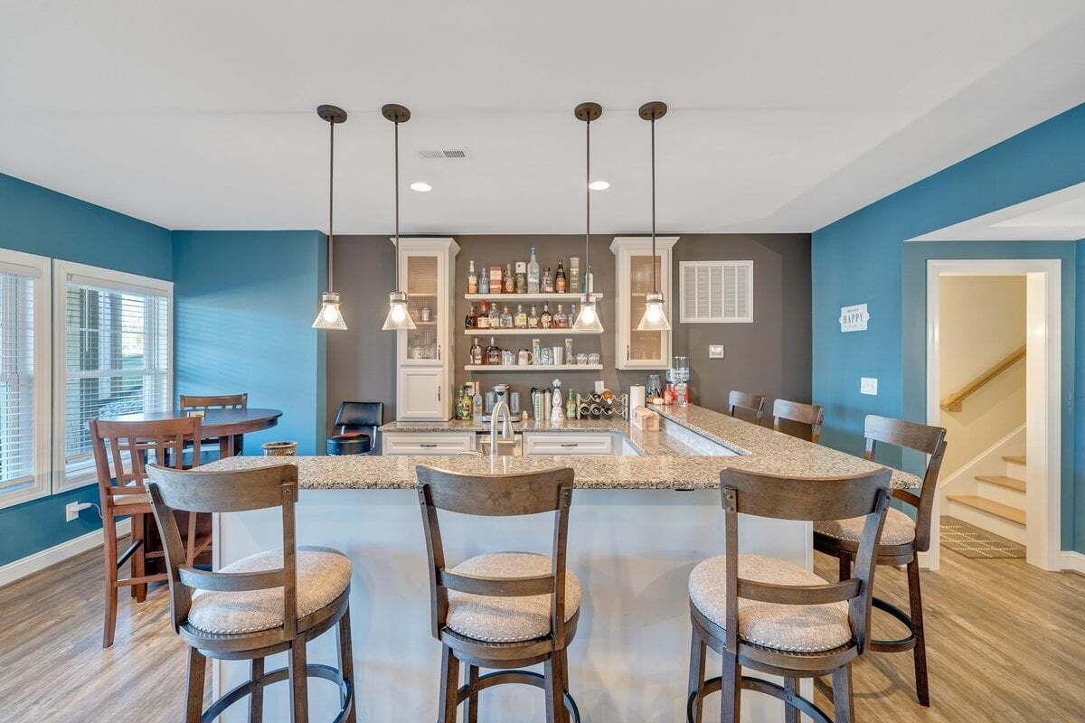 Una cocina moderna con una isla central, iluminación colgante y una zona de bar.