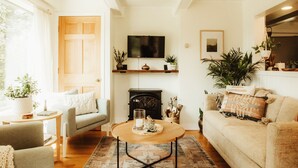 Una sala de estar acogedora con chimenea, un televisor montado encima y un sofá cómodo.