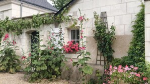 Un bâtiment en pierre, orné de lierre et de plantes à fleurs.