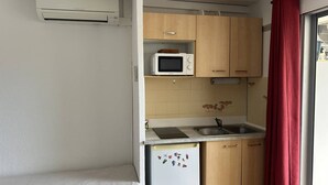 A compact kitchenette with a microwave, sink, and refrigerator. - Pleasant studio cabin apartment in residence with pool near Richelieu beach, Cap d'Agde (LE CAP D AGDE)