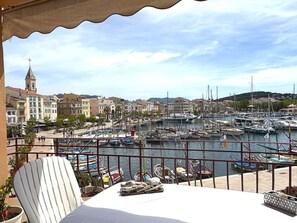 Ein Balkon mit Blick auf einen Yachthafen, Boote und Gebäude.