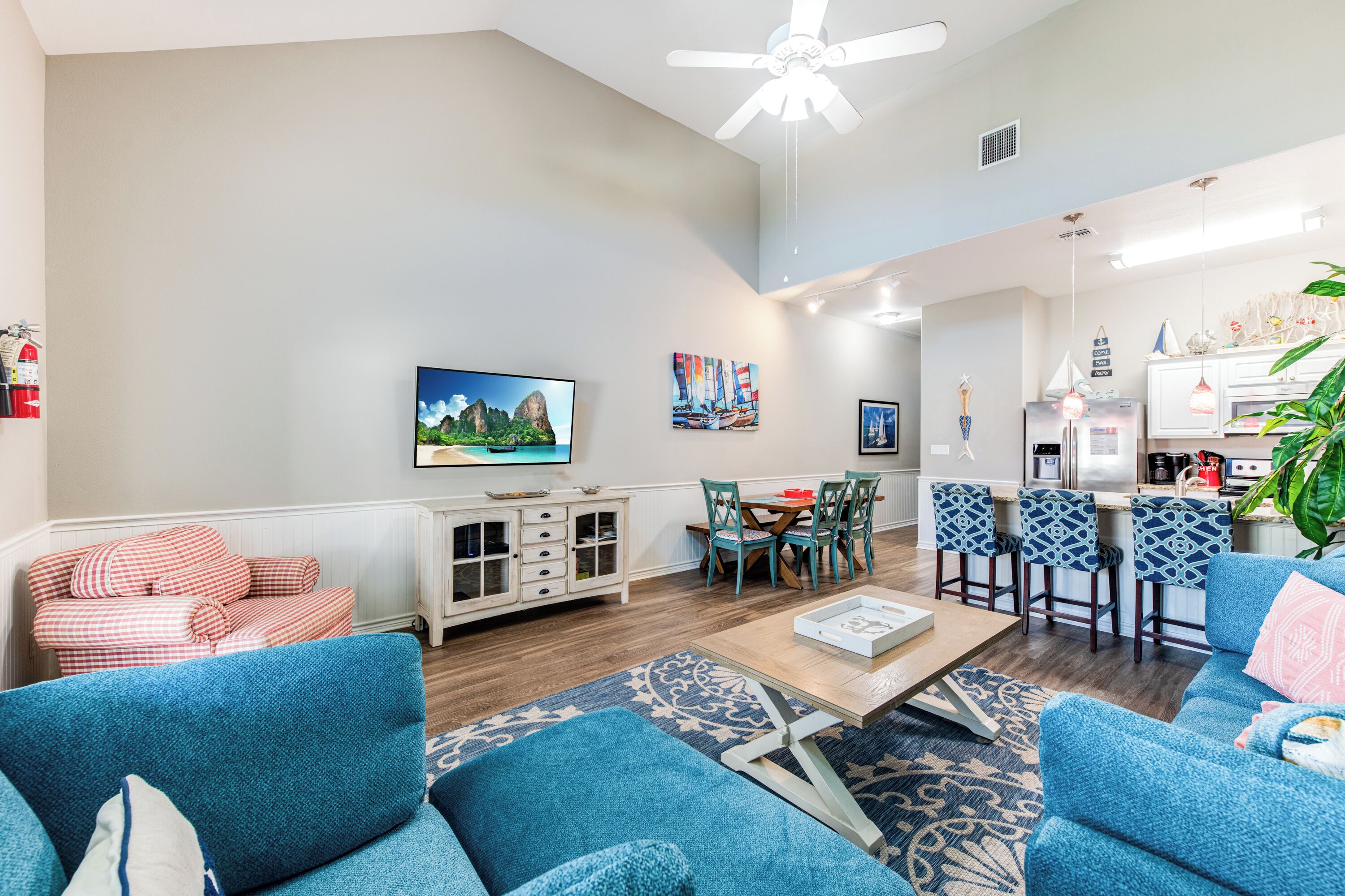 A modern living room with a sofa, a coffee table, and a dining area with chairs and a table.