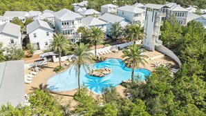 A resort with multiple white buildings, a central swimming pool, and surrounding palm trees. - Highland Parks, Resort-Style Pool! LSV/Golf Cart & 6 Bikes! (Santa Rosa Beach)