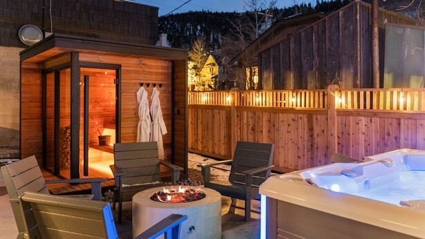 Une cabane en bois dotée d’un bain à remous, d’un espace extérieur aménagé et d’un sauna.