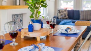 A dining table with a plant, salt and pepper shakers, wine glasses, and a plate with a blue and white pattern. - Explore Mayberry: 2 King Masters, 3 Bed / 3 Bath, Fire Pit (Mount Airy)