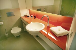 A bathroom with a white sink, a mirror, and a toilet. - Conference Partner Ullrich (Elfershausen)