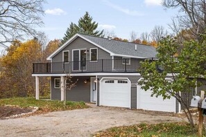 A two-story house with a balcony, a garage, and a driveway.