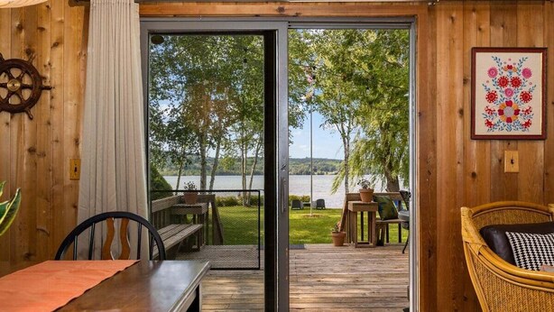 A wooden interior with a sliding glass door leading to an outdoor deck. - Camp Birch: Waterfront Home on Lake Leelanau (Lake Leelanau)