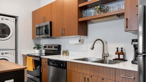 Una cocina moderna con electrodomésticos de acero inoxidable, armarios de madera y un microondas integrado.