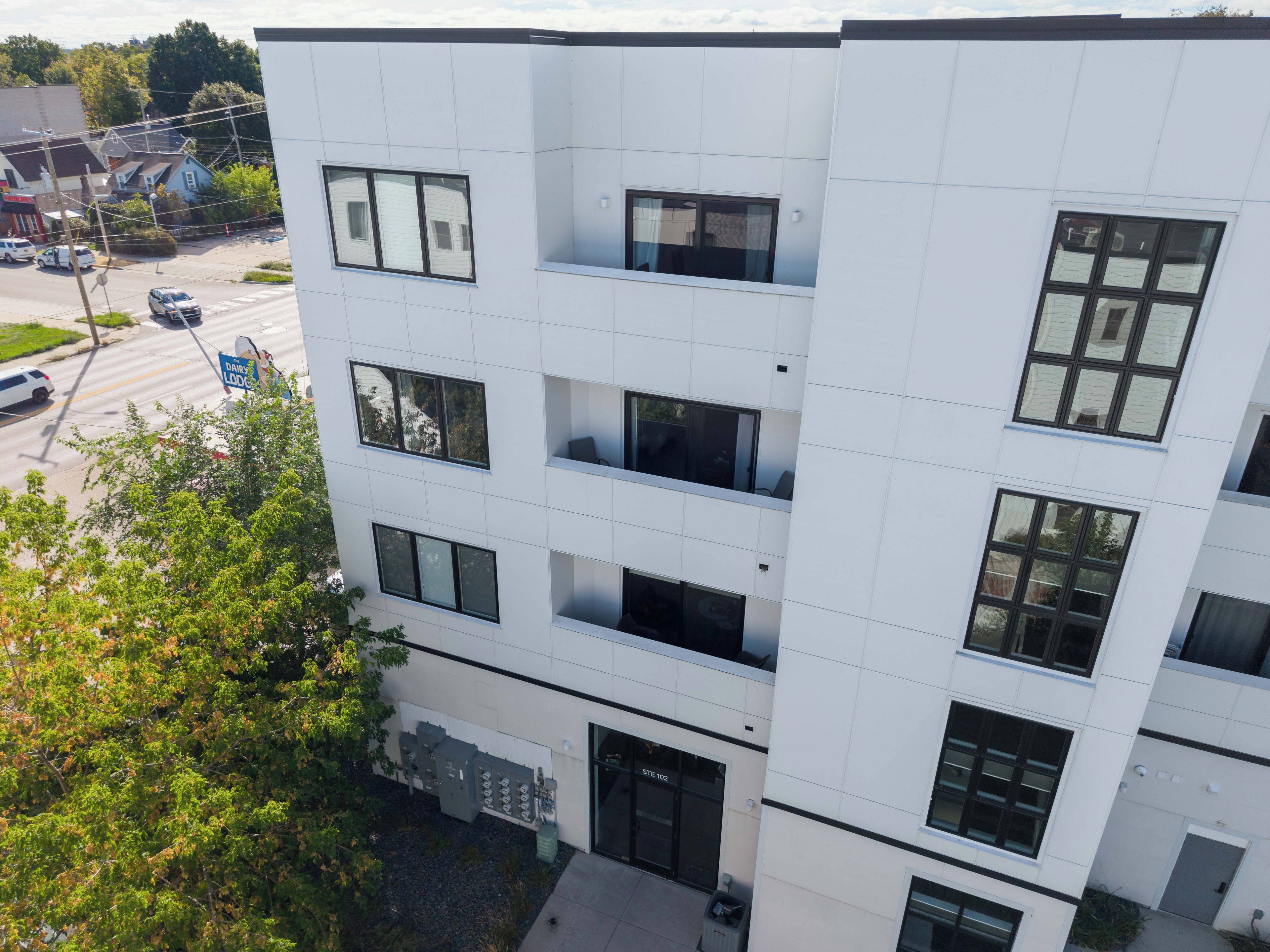 En byggnad med flera våningar, en slät fasad, stora fönster och en tydligt markerad entré.