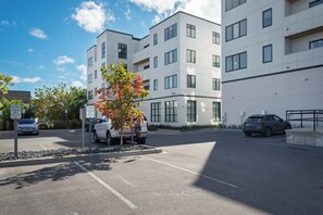 Moderni, useita kerroksia sisältävä rakennus, jossa on parkkipaikkoja ja kirkas taivas.