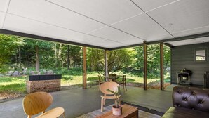 A modern living room with a sofa, a wooden coffee table, and two chairs. - Bayside Bungalow: West Bay Views Minutes to TC (Traverse City)