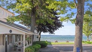 A beachfront property with a covered patio, a private beach sign, and a view of the sea. - #01 Beach Bungalow at Lakeshore Resort (Traverse City)