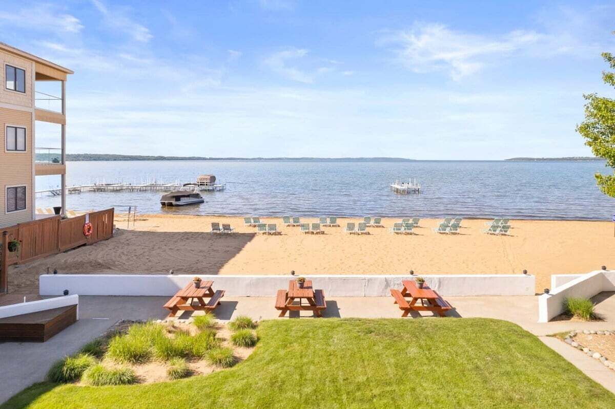 Blick auf einen Strand mit Pool, Liegestühlen und Picknicktischen.