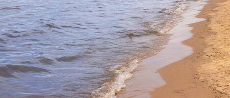 Een strand met zachte golven die op het strand komen.
