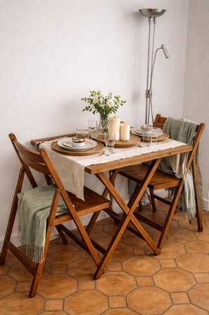 A dining table with a white tablecloth, wooden chairs, and a vase with flowers. - RARE Paris XV- ideal location 🏠 House with large courtyard (Paris)