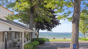 Ein Gebäude am Wasserufer mit überdachter Terrasse, einem Schild für einen Privatstrand und Blick auf das Wasser.