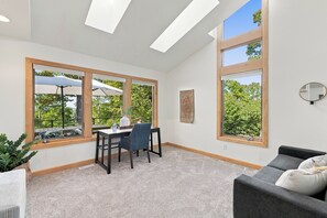 Una habitación moderna con una mesa de comedor, sillas y un ventanal con vistas a zonas verdes.