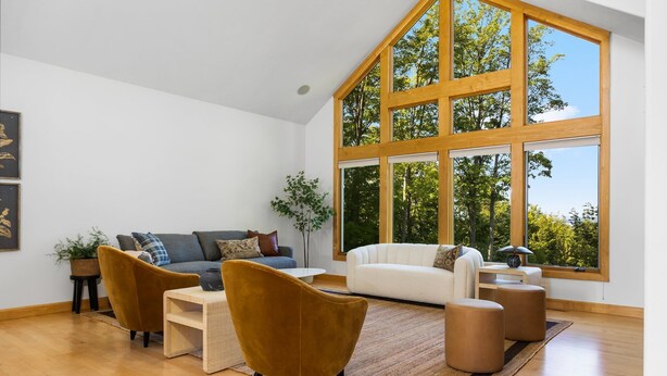 A spacious living room with a high ceiling, large windows, and a modern interior design. - Seven Hills Estate on Old Mission (Traverse City)