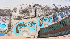 A beach resort with a large pool area, a sandy beach, and a view of the ocean. - NEW Phoenix Gulf Tower II Unit 2508 | Luxury East Corner - Gorgeous Coastal Decor, Stunning Views (Orange Beach)