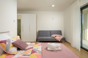 A bedroom with a bed, a sofa, a wardrobe, and a window with curtains. - Villa Diego (Istria - Pula) (Prodol)