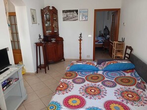 A bedroom with a bed, a wooden cabinet, a television, and a desk. - 30m from the beach| Waterfront apartment (Riva Trigoso)