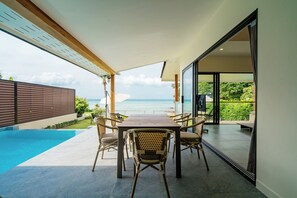 A dining area with a view of the sea, a pool, and a modern architectural design. - Elegante villa neuve avec piscine sur la plage, vue imprenable (Koh Samui)