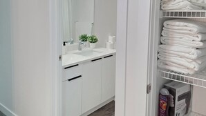 A modern bathroom with a white sink, mirror, and towel rack. - Fort Delight 3 bedroom house Netflix/wifi/Free parking (Fort Saskatchewan)