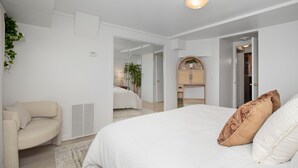 Une chambre à coucher avec un grand lit, une chaise, une armoire et un miroir.