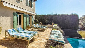A villa with a pool, outdoor lounge chairs, and a well-maintained garden. - MAISON PROVENÇALE AVEC PISCINE (Saint-Paul-De-Vence)
