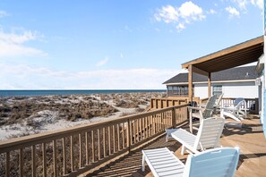Expansive oceanfront deck in Oak Island NC with pergola shade, Adirondack chairs, and wooden railing overlooking rolling dunes and direct Atlantic Ocean views just steps from the beach path. - Rest a Shored: Spacious 4BR oceanfront retreat in Oak Island, NC, perfect for families! (Oak Island)