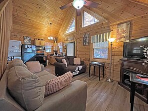 A cozy cabin interior with a living room, kitchen, and a TV. - Moonlight Ridge Cabin (Bryson City)