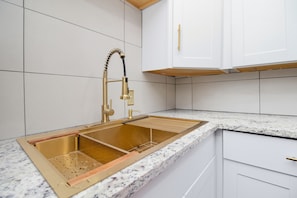 A kitchen with a stainless steel sink, white cabinets, and a granite countertop. - Fabulous 1-bedroom apartment in vibrant Atlanta Near Midtown, Emory University (Atlanta)