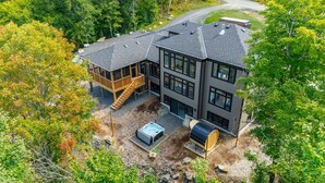 Una casa moderna de dos pisos con un balcón, un jacuzzi y una sauna.