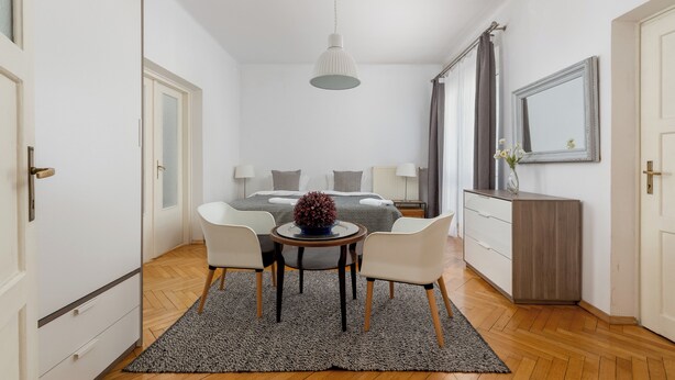 Un dormitorio moderno con cama, mesitas de noche, un escritorio y una silla.