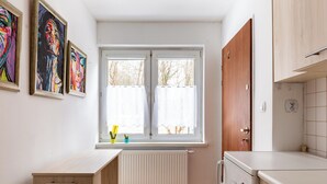 Cocina pequeña con ventana, radiador y armarios de madera.
