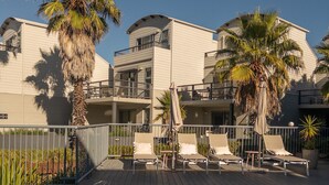 A hotel with a pool, palm trees, and lounge chairs. - 2 Bedroom Open plan,combined living & dining areas with fully self contained kitchen & laundry. (Batehaven)