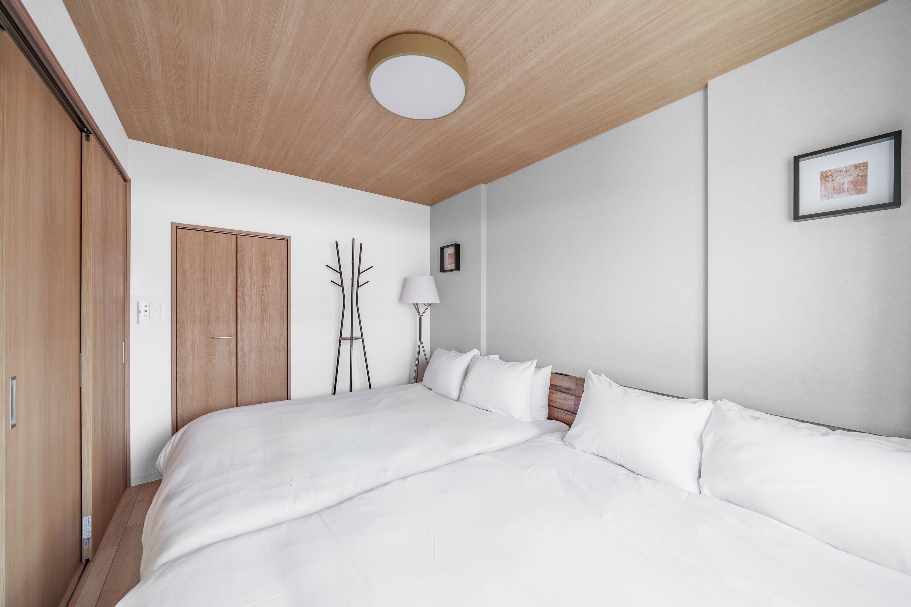 Ein Schlafzimmer mit einem großen Bett, einem Holzschrank und einer Deckenleuchte.