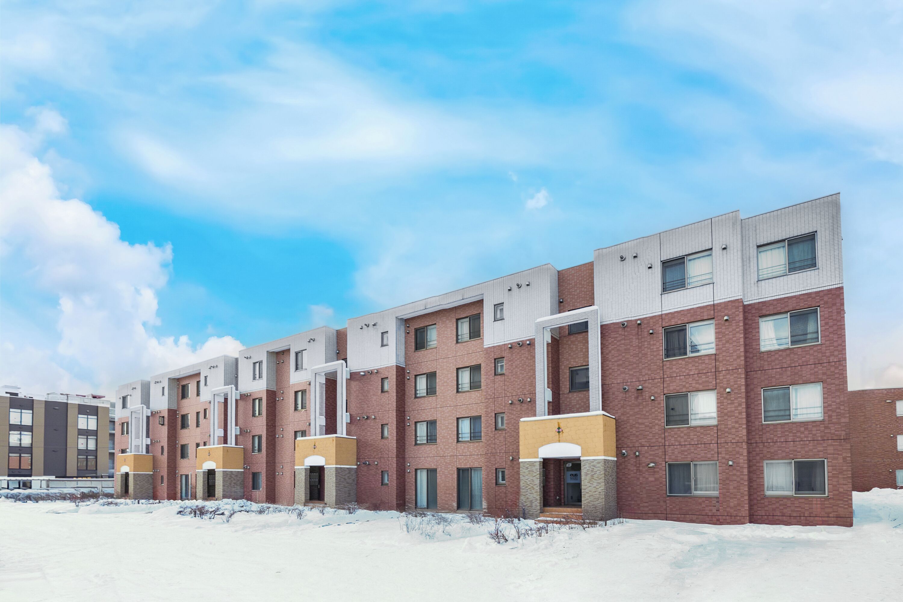 A multi-story residential building with a brick facade and multiple windows.