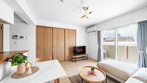 Una sala moderna con comedor, televisor y balcón con vistas.