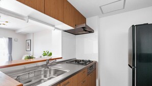 Una cocina moderna con armarios de madera, electrodomésticos de acero inoxidable y un refrigerador negro.