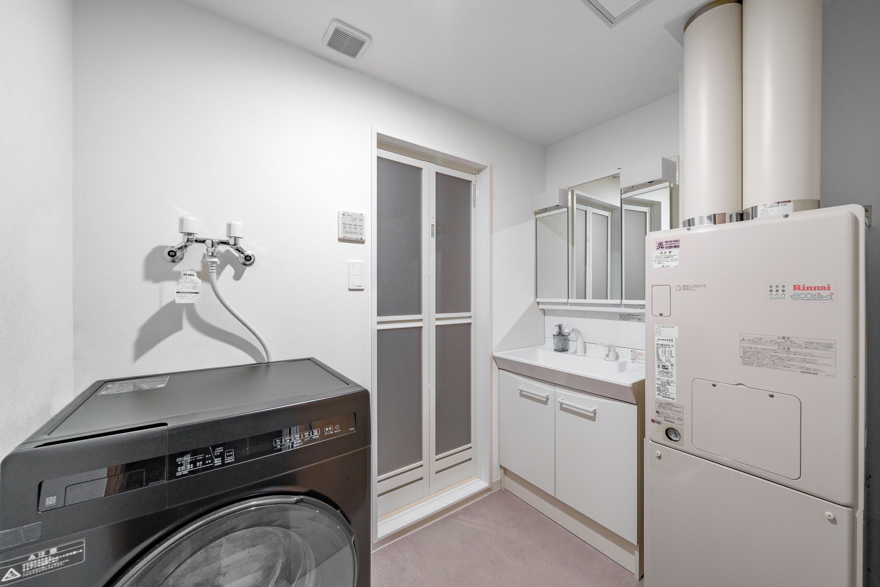 A compact laundry room with a washing machine, a dryer, and a refrigerator.