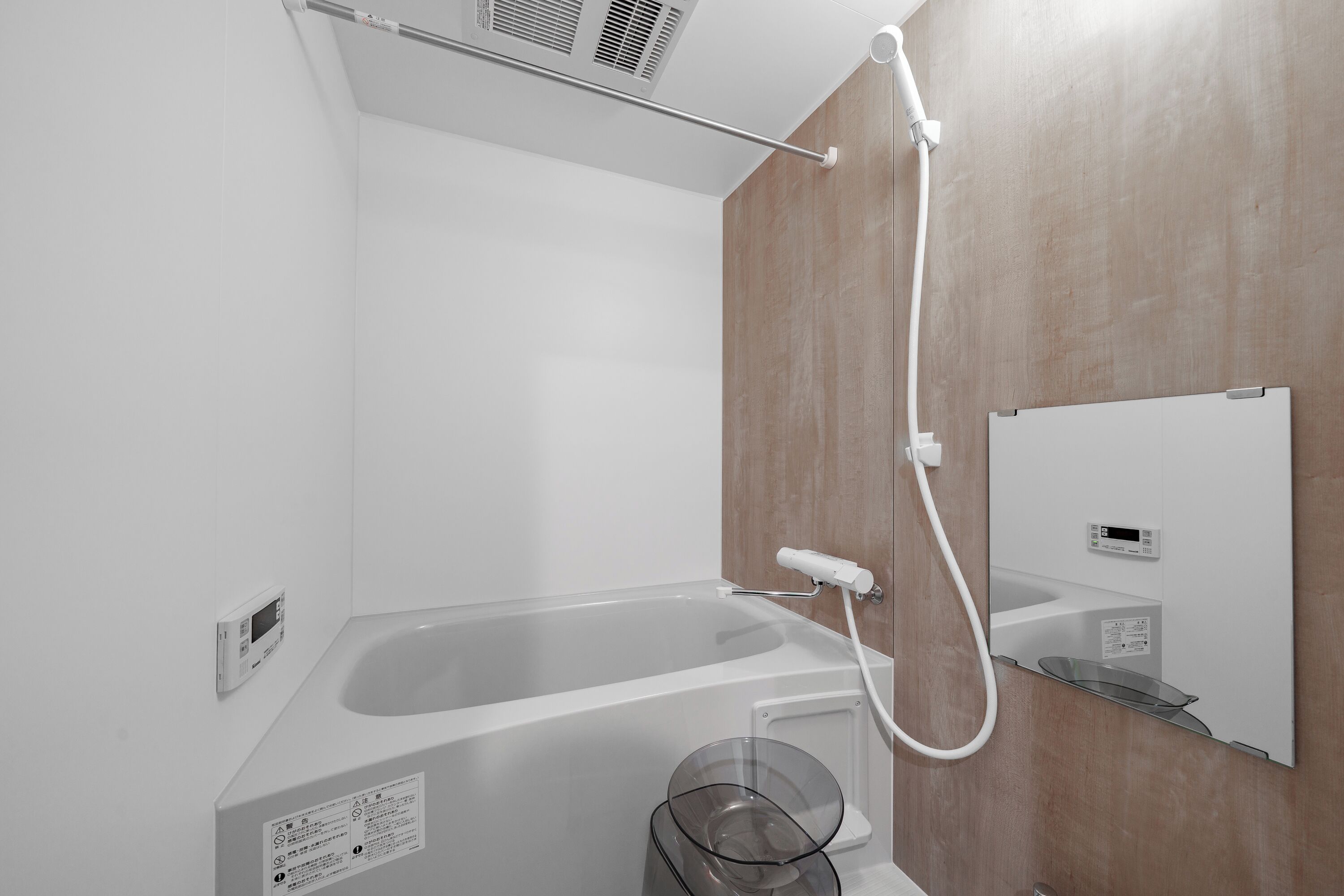 Un baño moderno con bañera, ducha de mano y panel de control.