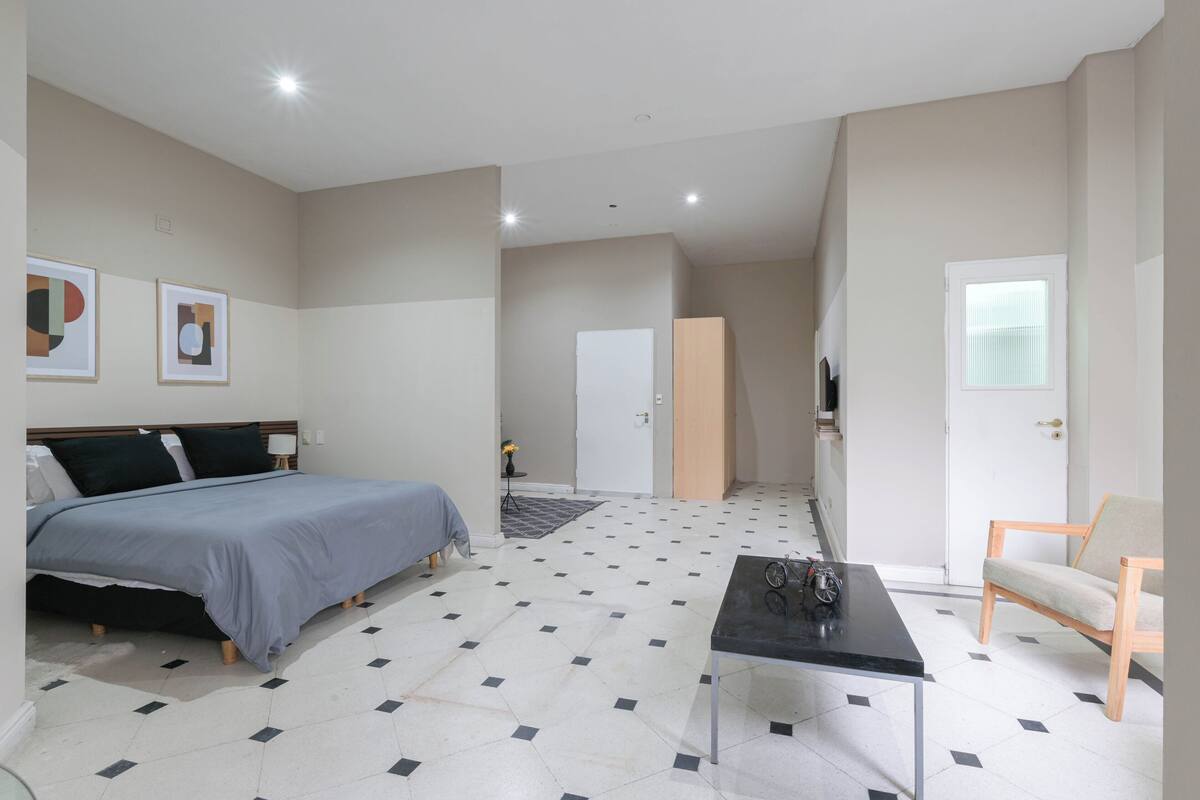 Ein Schlafzimmer mit Bett, Schreibtisch, Stuhl und Kleiderschrank.