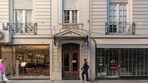 A building with a shop entrance labeled 'Leonardo da Vinci,' a balcony with ornate metal railings, and a storefront with a '40% off' sign. - Leonardo Da Vinci Aparts by MOT Rentals (Buenos Aires)