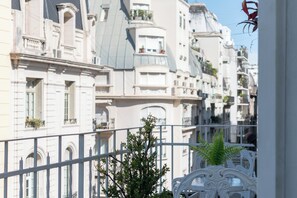Une rangée de bâtiments blancs, dotés de balcons et d’une balustrade blanche au premier plan.