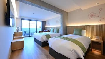 Une chambre d’hôtel moderne avec deux lits, un bureau et une vue sur l’extérieur.